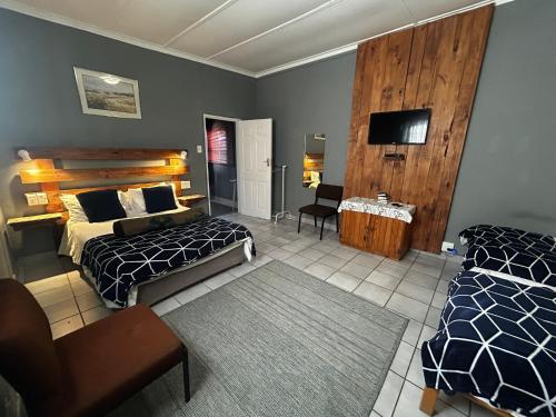 Un dormitorio con dos camas y un televisor de pantalla plana. en Karas-inn Bed and Breakfast, en Karasburg
