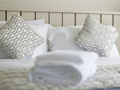 a bed with two pillows and a pile of towels at Transporter Lodge - Ukc4060 in Nunthorpe