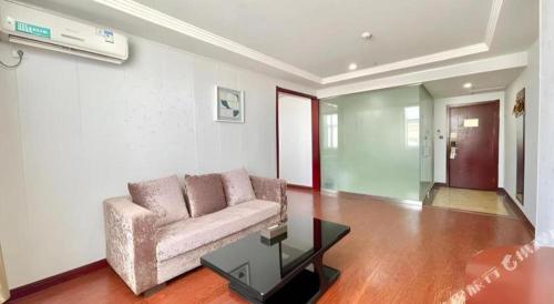 a living room with a couch and a glass table at GreenTree Inn Yinchuan Pedestrian Street East Liqun Street Express Hotel in Yinchuan