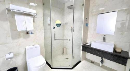 a bathroom with a shower and a toilet and a sink at GreenTree Inn Yinchuan Pedestrian Street East Liqun Street Express Hotel in Yinchuan