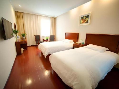 une chambre d'hôtel avec deux lits et une table dans l'établissement GreeTree Inn Suzhou Industrial Jinji Lake Xinhujie Gaojiaoqu, à Suzhou