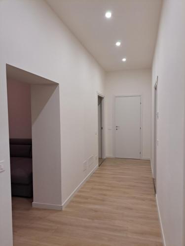 an empty hallway with white walls and wood floors at San Francesco Home in Terni