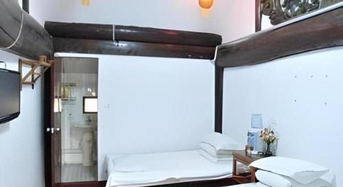 a room with a bed and a mirror in it at Pingyao Yufengheng Hotel in Pingyao