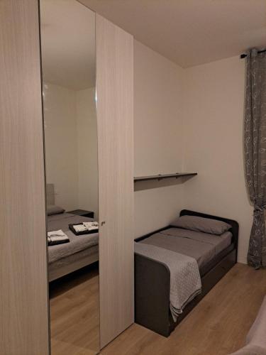 a bedroom with two beds and a mirror at San Francesco Home in Terni