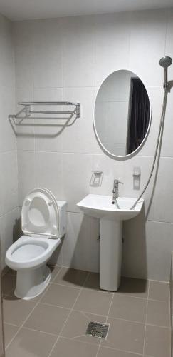 a bathroom with a toilet and a sink and a mirror at 숲속온천호텔 in Changwon