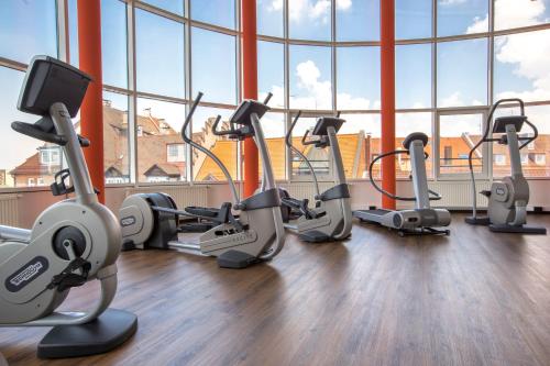 a gym with cardio equipment in a large room with windows at Park Inn by Radisson Nürnberg in Nuremberg