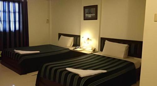 two beds in a hotel room with sidx sidx sidx sidx at Senesouk Hotel in Vientiane