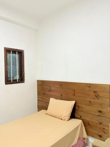 a bedroom with a bed with a wooden headboard at aka Spice House in Murutalawa