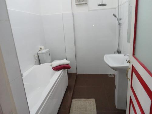 a small bathroom with a tub and a sink at aka Spice House in Murutalawa