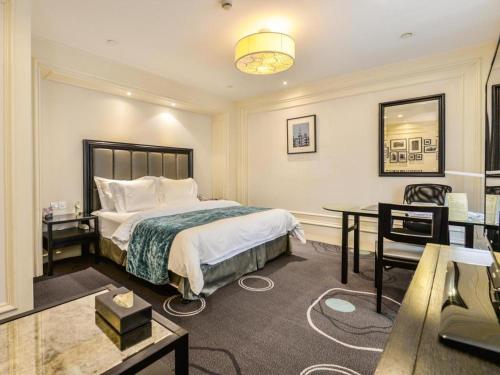 a hotel room with a bed and a desk at Jinjiang Metropolo Hotel Classiq YMCA People Square in Shanghai