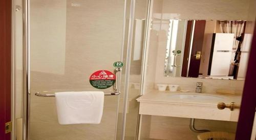 a bathroom with a shower and a sink with a mirror at GreenTree Inn Shanghai Minhang Development Zone Subway Station Business Hotel in Shanghai