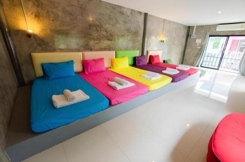 een kamer met 2 bedden en kleurrijke kussens bij The Rest Hotel in Ko Larn