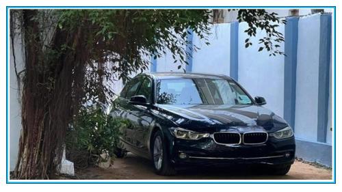 a black car parked next to a tree at Elvis Beach Resort in Trincomalee