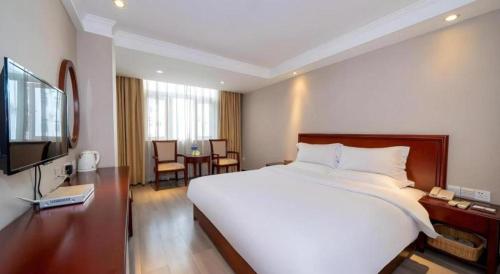 a hotel room with a large bed and a television at GreenTree Inn Nanning Langdong Hotel in Nanning