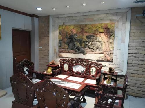 a dining room with a mural on the wall at Hihotel Saraburi in Sara Buri