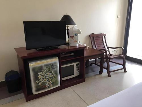a living room with a tv and a table with a microwave at Hihotel Saraburi in Sara Buri