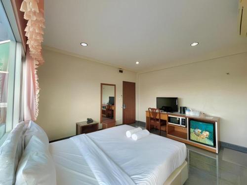 a bedroom with a white bed and a television at Hihotel Saraburi in Sara Buri