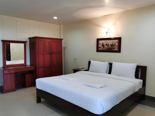 a bedroom with a large white bed and a mirror at Hihotel Saraburi in Sara Buri