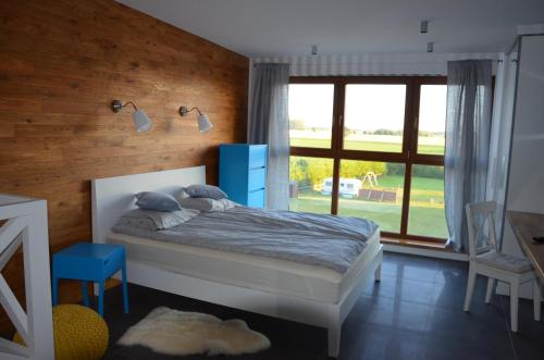 sypialnia z łóżkiem i dużym oknem w obiekcie Błękitna Laguna w mieście Puck
