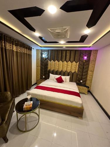 a bedroom with a large bed and a coffee table at Decent Luxury Hotel Skardu in Skardu