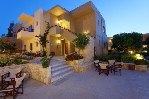 a building with a patio with tables and chairs at Indigo Mare in Plataniás