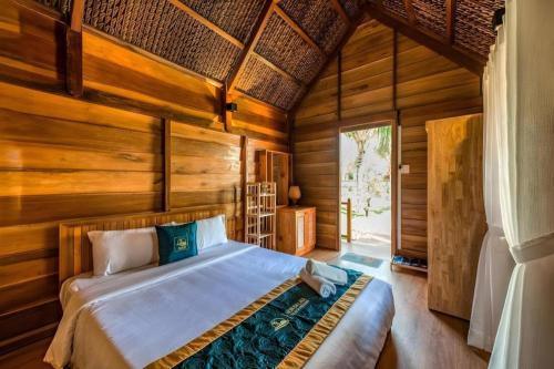 a bedroom with a bed in a room with wooden walls at HON BA LAGI BEACH RESORT in La Gi
