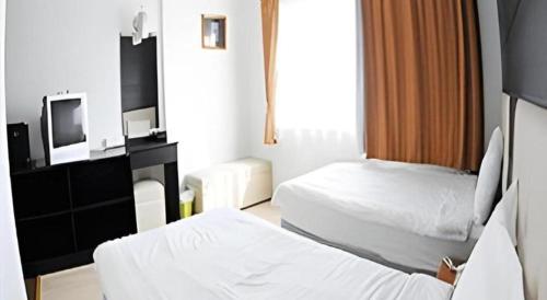 a hotel room with two beds and a television at Cactus Resort & Hotel in Khon Kaen