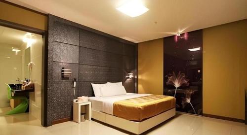 a bedroom with a bed and a black wall at Hotel Nyxfox in Cheonan