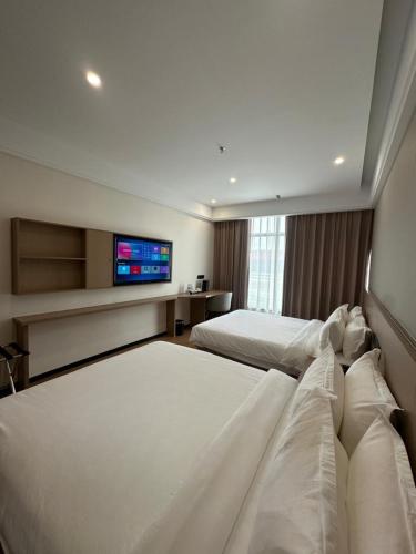 a hotel room with two beds and a flat screen tv at The MAJULAN Hotel in Kota Kinabalu