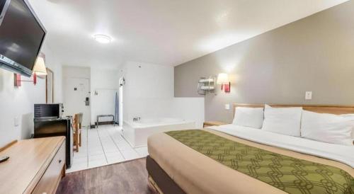 a hotel room with a large bed and a bathroom at Econo Lodge Truman Inn in Sedalia