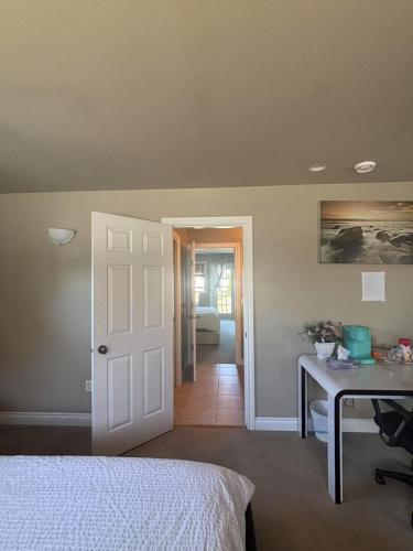 a bedroom with a bed and a desk and a door at Rosehouse 2Bedrooms sleep 4 2nd floor private bathroom in Coquitlam