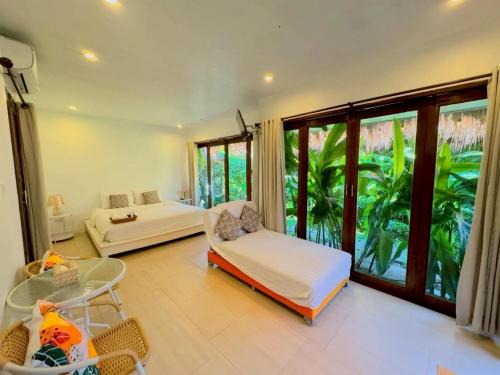 a living room with a bed and a large window at The bora bora - Bed and Dream เดอะ โบรา โบร่า - เบด แอนด์ ดรีม in Ban Chek