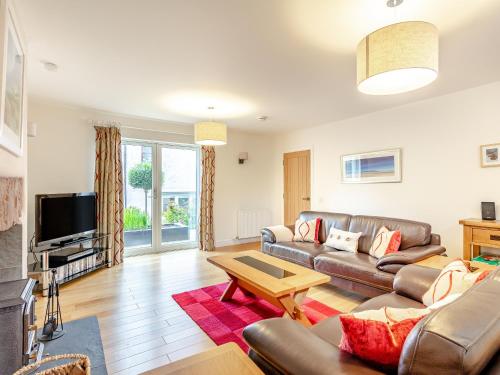 een woonkamer met een bank en een tafel bij Rose Cottage - Uk39245 in Inverness