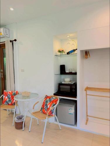 a kitchen with a table and chairs and a microwave at The bora bora - Bed and Dream เดอะ โบรา โบร่า - เบด แอนด์ ดรีม in Ban Chek