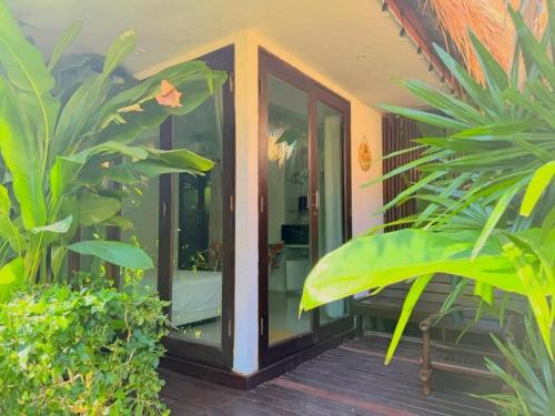 an entry to a house with glass doors and plants at The bora bora - Bed and Dream เดอะ โบรา โบร่า - เบด แอนด์ ดรีม in Ban Chek