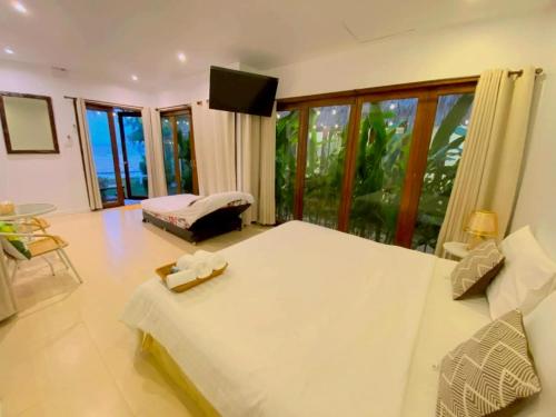 a bedroom with a large bed and a large window at The bora bora - Bed and Dream เดอะ โบรา โบร่า - เบด แอนด์ ดรีม in Ban Chek