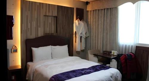 a bedroom with a large bed in a hotel room at Benikea Ariul Hotel in Gunsan