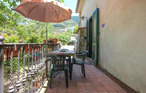 a table and chairs with an umbrella on a balcony at Nice Apartment In Serramezzana With Wifi in Serramezzana