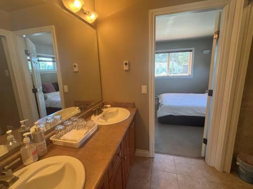 a bathroom with two sinks and a large mirror at Rosehouse 2Bedrooms sleep 4 2nd floor private bathroom in Coquitlam