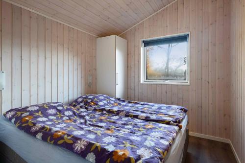 Un dormitorio con una cama en una habitación con ventana. en Charming Cottage In Fjellerup With Indoor Spa, en Glesborg