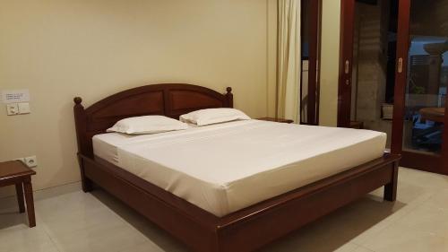 un letto con due cuscini sopra in una stanza di Keke homestay sanur a Sanur