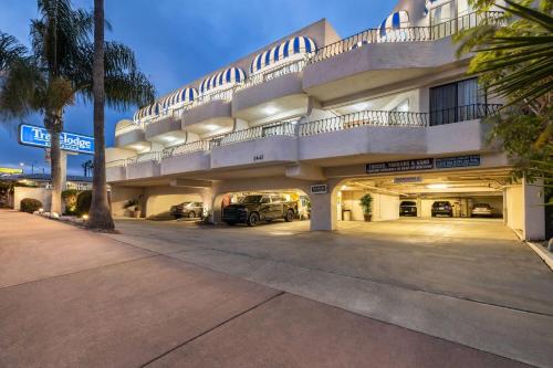 a large building with cars parked in a parking lot at Travelodge by Wyndham San Clemente Beach in San Clemente