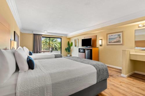 a hotel room with two beds and a television at Travelodge by Wyndham San Clemente Beach in San Clemente