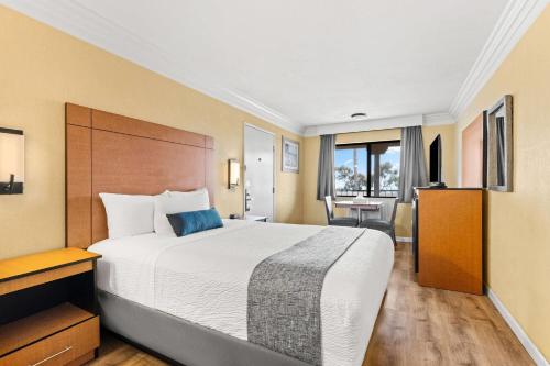 a hotel room with a large bed and a desk at Travelodge by Wyndham San Clemente Beach in San Clemente
