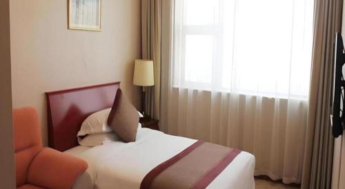 a hotel room with a bed and a window at Shaanxi Business Hotel in Shanghai