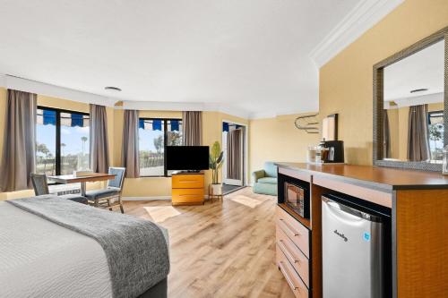 a hotel room with a bed and a desk with a mirror at Travelodge by Wyndham San Clemente Beach in San Clemente