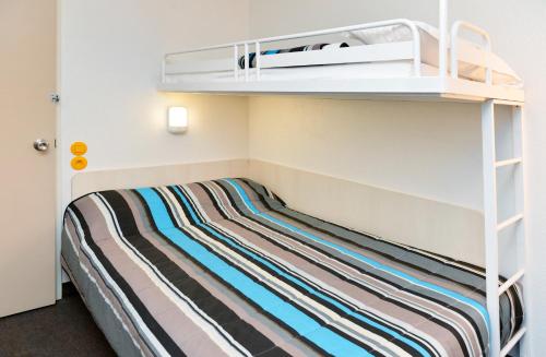 a bedroom with a bunk bed with a striped mattress at Lemon Hôtel Coudes in Coudes