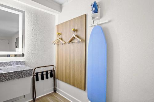 a bathroom with a blue surfboard on a wall at Days Inn by Wyndham Salem in Salem