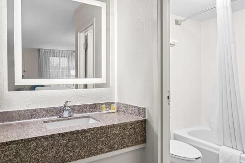 a bathroom with a sink and a toilet and a mirror at Days Inn by Wyndham Salem in Salem
