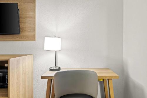 a room with a desk with a chair and a lamp at Days Inn by Wyndham Salem in Salem